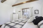 Primary bedroom with a king size bed and window AC unit
